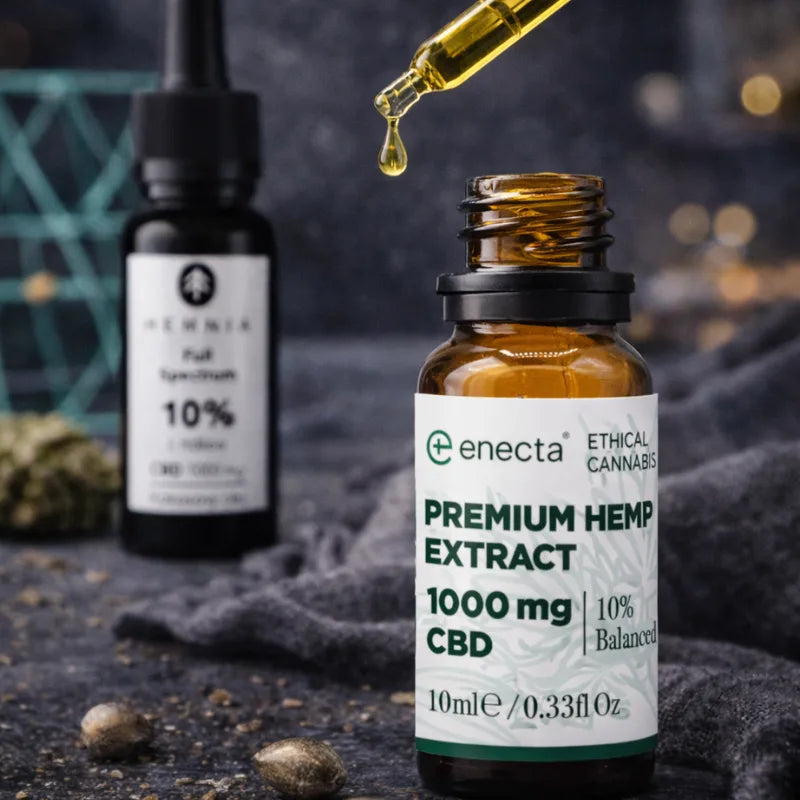 Enecta Premium Hemp Extract CBD Öl mit tropfender Pipette im Fokus, Hemnia Full Spectrum Flasche unscharf im Hintergrund